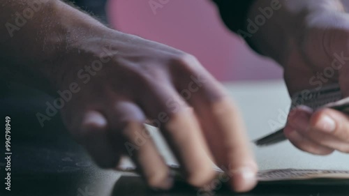 The man picks up a stack of banknotes