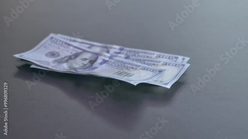 The man picks up a stack of banknotes