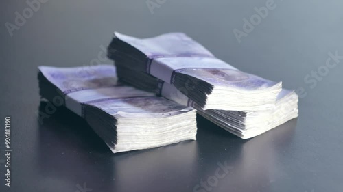 A close-up shot of a man's hands counting Ukrainian banknotes. The details of the bills, including the denomination and design of Ukraine's national currency, are clearly visible