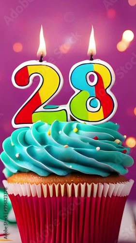 Birthday cupcake with burning lit candle with number 28. Number twentyeight for twentyeight years or twentyeighth anniversary. photo