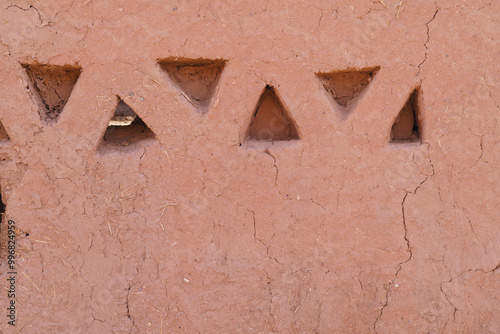 Red clay wall with triangular niches 