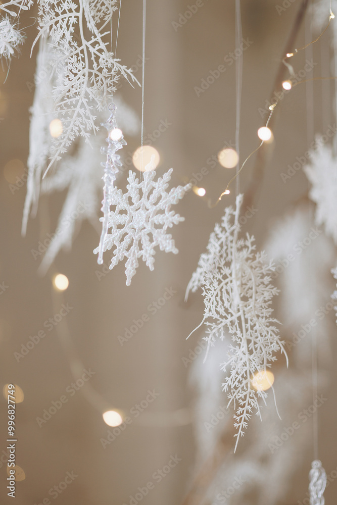 Christmas decorations white snowflakes and garland with blurred yellow lights. High quality photo Christmas decorations white snowflakes and garland with blurred yellow lights. High quality photo