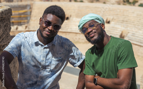 Two men smiling and posing in front of El Jem's Amphitheater. photo