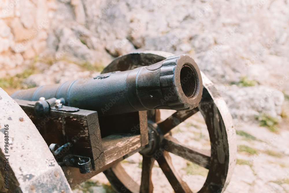 Cannon on a carriage located on a white stone pedestal near the arsenal building in Mirow Castle. Sites of Poland. Architecture of World Tourism. High quality photo Cannon on a carriage located on a white stone pedestal near the arsenal building in Mirow Castle. Sites of Poland. Architecture of World Tourism. High quality photo
