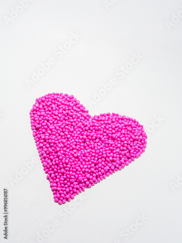 Heart shaped pink masterbatch granules isolated on white background,color pigment carrier polymer in plastic industry