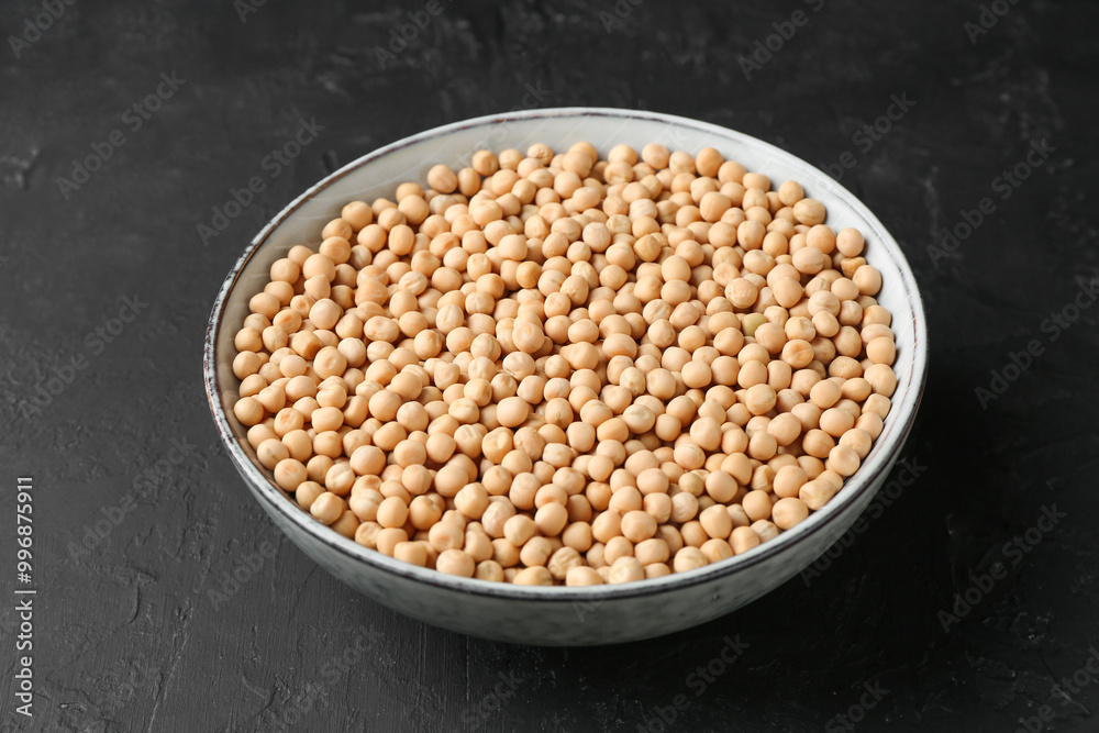 Dried peas in bowl on dark textured table, closeup Dried peas in bowl on dark textured table, closeup