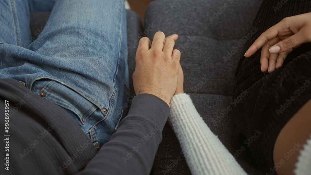 A man and woman lovingly hold hands, symbolizing relationship and togetherness in a cozy home interior. A man and woman lovingly hold hands, symbolizing relationship and togetherness in a cozy home interior.