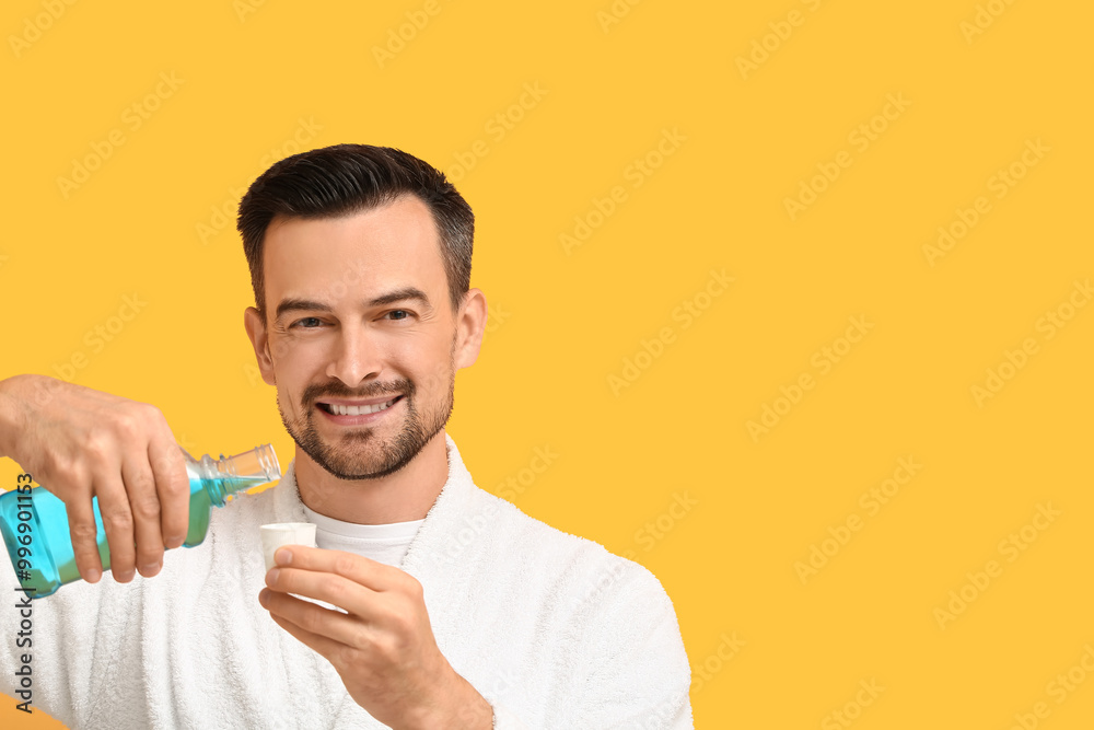 Handsome man with mouth rinse on yellow background Handsome man with mouth rinse on yellow background