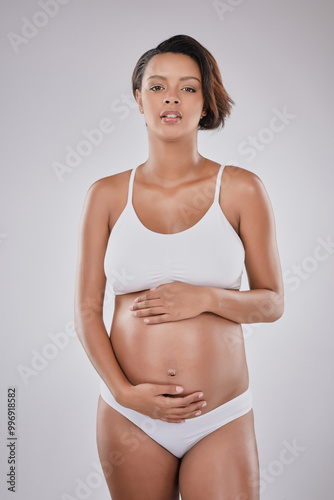 Woman, face and underwear in studio for pregnant, motherhood and stomach growth with prenatal care. Female person, portrait and lingerie on white background for pregnancy, maternity and gynecology