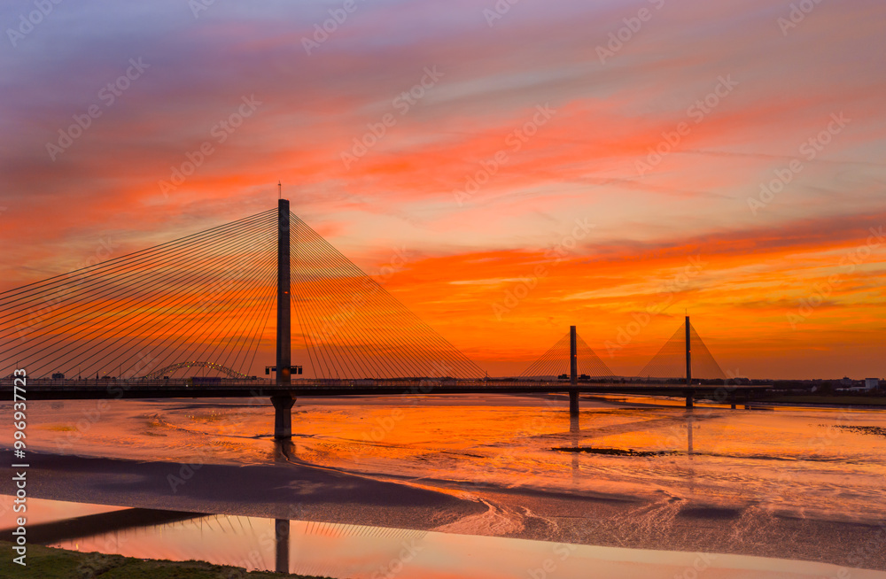 Liverpool, Merseyside, UK, September 18, 2024; aerial view of the Mersey Gateway toll bridge with stunning sun set over the River Mersey, Liverpool, UK. Liverpool, Merseyside, UK, September 18, 2024; aerial view of the Mersey Gateway toll bridge with stunning sun set over the River Mersey, Liverpool, UK.