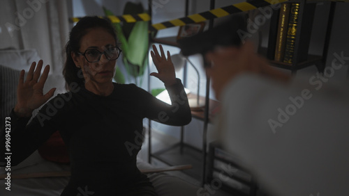 Fotografie A policewoman apprehends a surrendering woman in a dimly-lit indoor crime scene