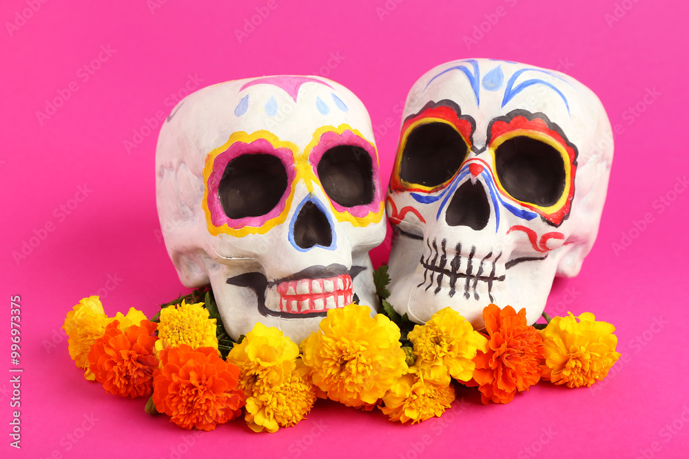 Composition with painted human skulls and beautiful marigold flowers on color background. El Dia de Muertos Composition with painted human skulls and beautiful marigold flowers on color background. El Dia de Muertos