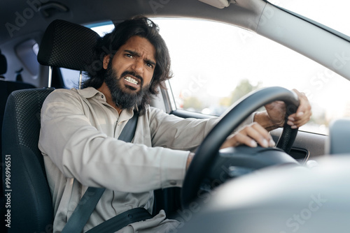 Traffic Issue. Angry Middle Eastern Driver Man Shouting Driving Car, Gesturing From Opened Automobile Window, Having Conflict On Road During Auto Ride In City, Side View Portrait, Selective Focus