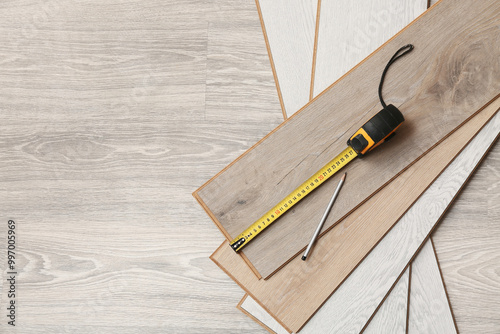 Measuring tape and laminate boards on floor photo