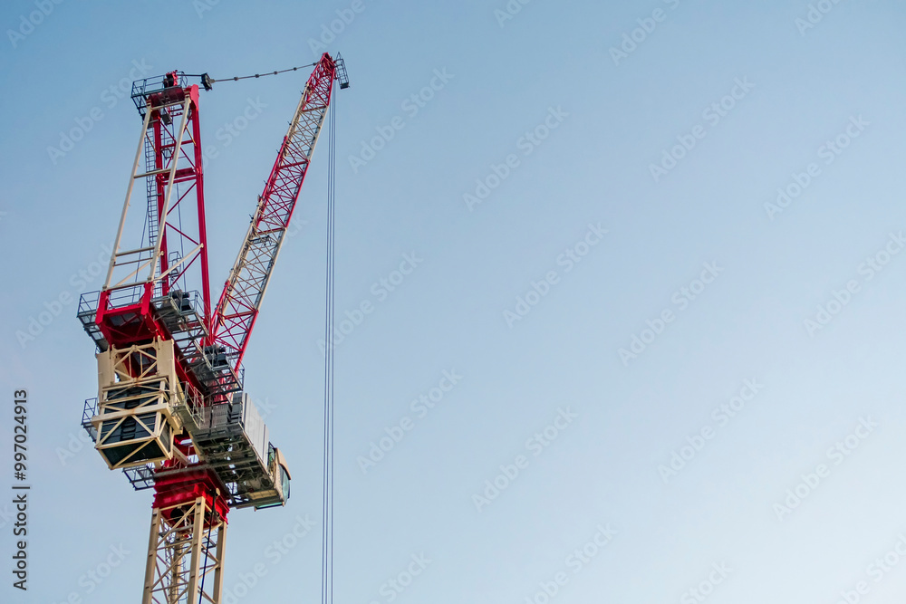 Big Construction tower crane against a clear blue sky Big Construction tower crane against a clear blue sky