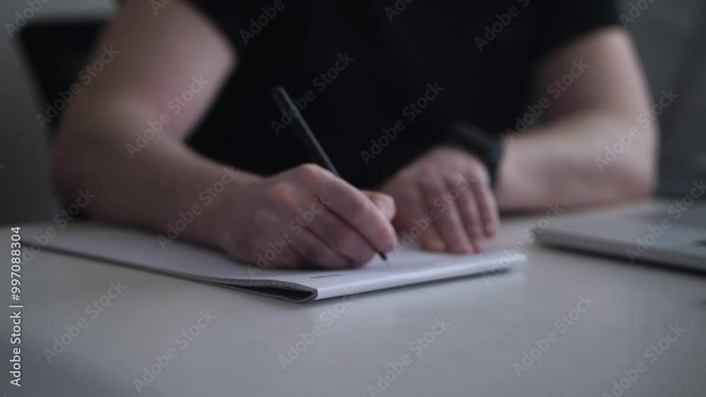 Man Writing Ideas While Working on Laptop Man Writing Ideas While Working on Laptop