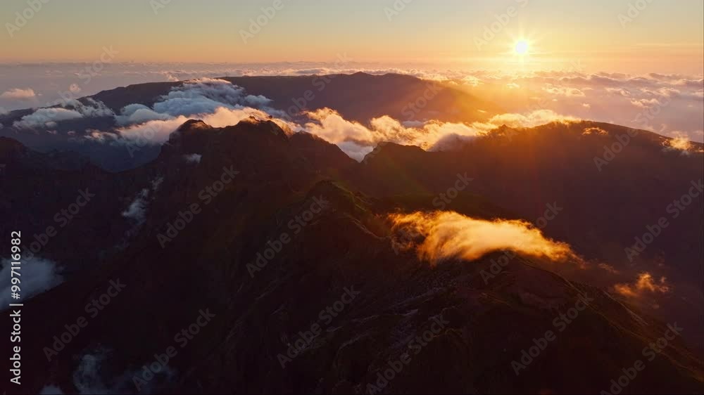 Aerial view of flying at Pico Ruivo of mountains with clouds on sunset. Madeira island, Portugal. Pull away out retreat dolly shot