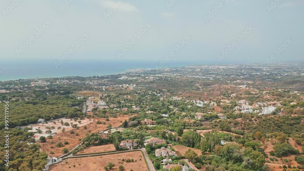 Aerial shot over greenery in Marbella, Spain towards the coast Aerial shot over greenery in Marbella, Spain towards the coast