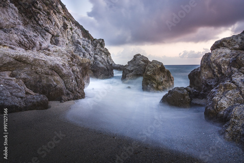 Long Exposure of Rocky Cliffs at Sunset with Smooth Water Effect