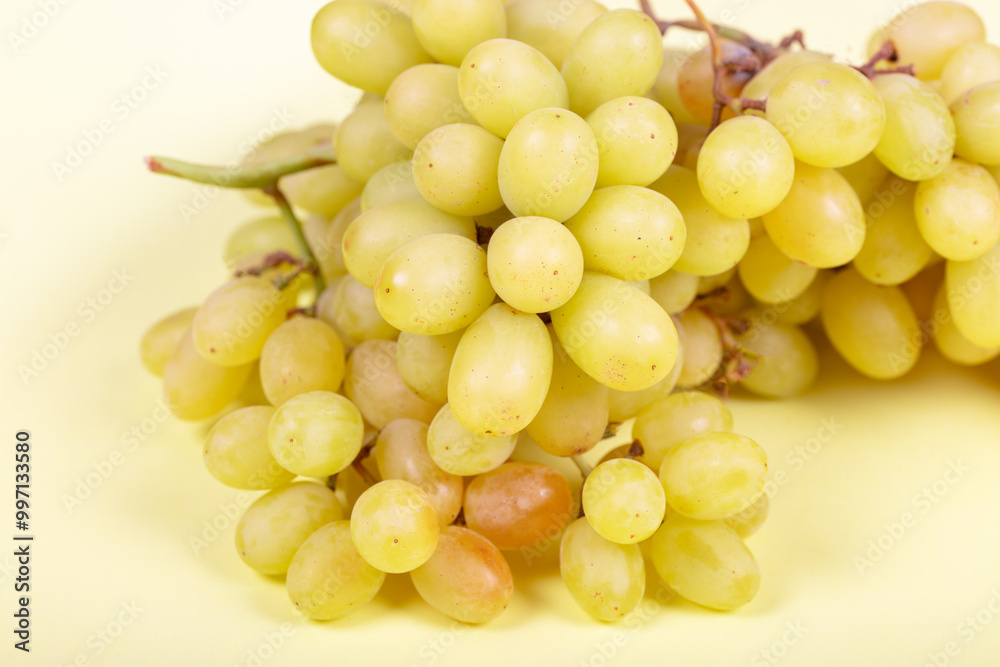 Fresh Green Grapes: Juicy Bunch of Sweet Table Grapes on Pale Yellow Background - Healthy Snack, Organic Produce, and Natural Fruit Photography Fresh Green Grapes: Juicy Bunch of Sweet Table Grapes on Pale Yellow Background - Healthy Snack, Organic Produce, and Natural Fruit Photography