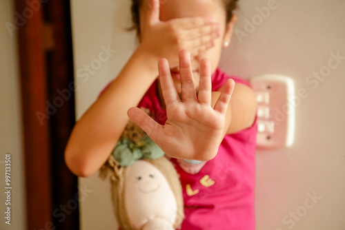 Criança em Silêncio com PARE escrito na mão  Abuso e a Exploração Infantil. 