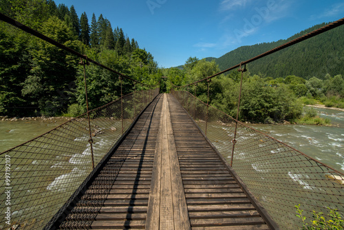 suspension cable bridge over the Cheremosh River in the Carpathian Mountains,...