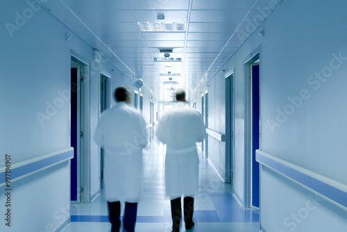 Two doctors walking in a hospital corridor. Science research concept.