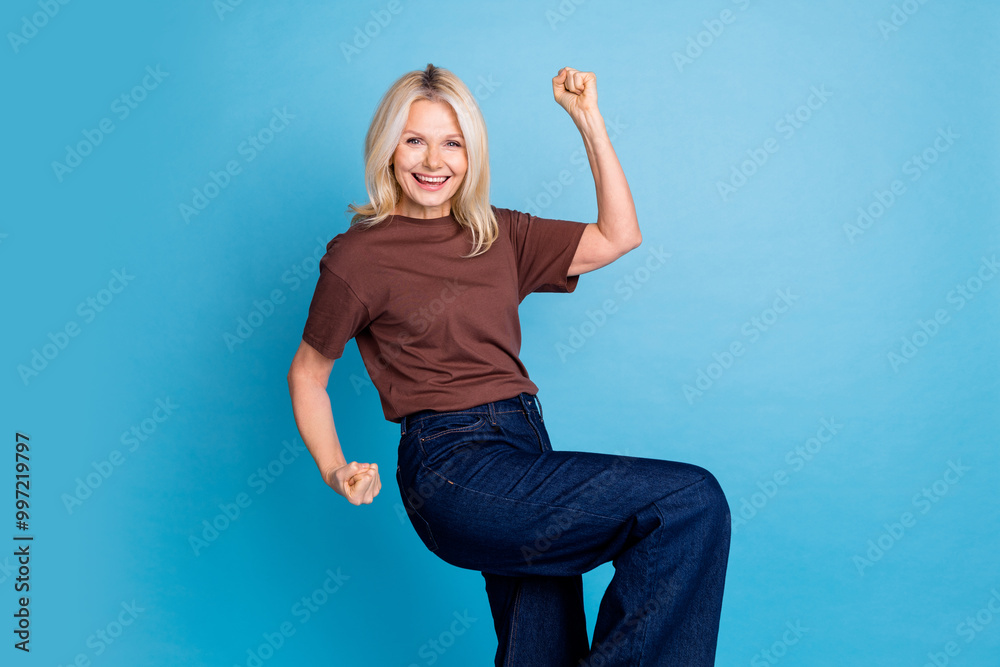 Φωτογραφία Photo of cheerful glad lovely woman wear trendy clothes raise hand fist isolated