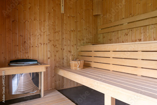 Wooden Sauna With Benches. The sauna is empty. The wooden benches provide seating for people.