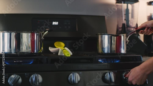 Woman prepares to cook on gas stove in modern kitchen setting