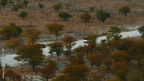 White pick up four by four carrying equipment, driving on the sand of the Namib desert .