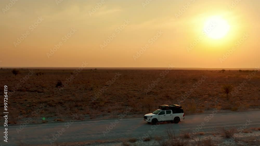 White pick up four by four carrying equipment, driving on the sand of the Namib desert . White pick up four by four carrying equipment, driving on the sand of the Namib desert .
