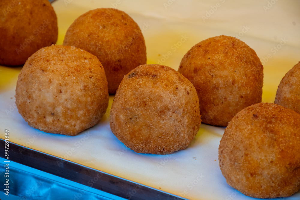 Fototapeta premium Sicilian street food arancini, deep fried rice croquettes with different fillings on market