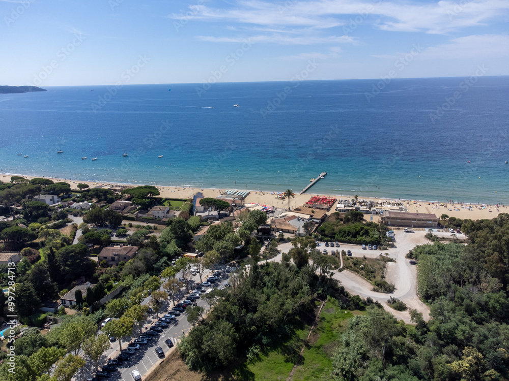 Fototapeta premium Aerial view on boats, crystal clear blue water of Plage du Debarquement white sandy beach near Cavalaire-sur-Mer and La Croix-Valmer, summer vacation on French Riviera, Var, France