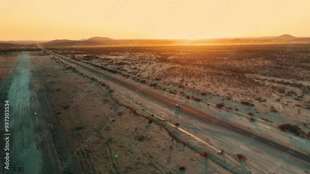 White pick up four by four carrying equipment, driving on the sand of the Namib desert .