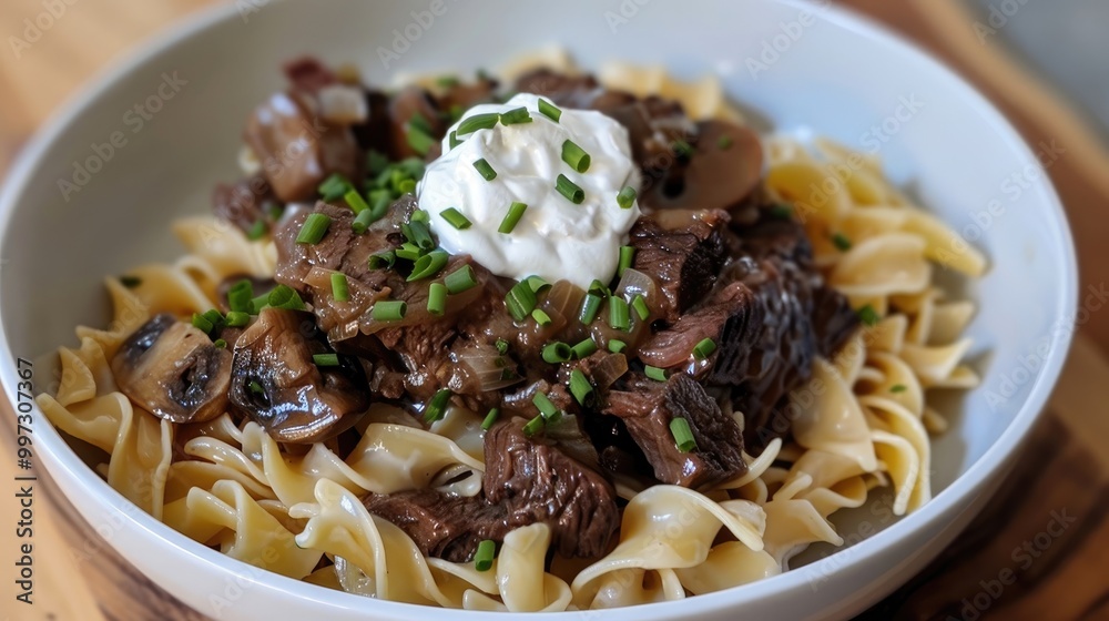 Tender beef tips with mushrooms and onions over egg noodles, sour cream, and chives Tender beef tips with mushrooms and onions over egg noodles, sour cream, and chives