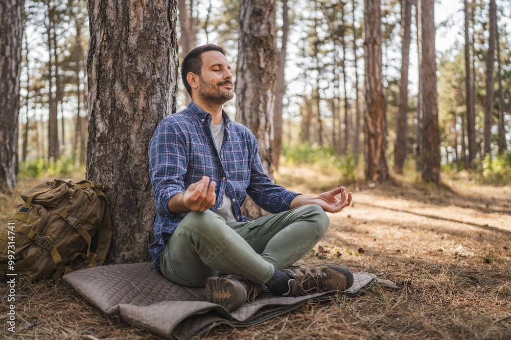 Obraz premium Adult man camper practice meditation and breath exercise in front tree