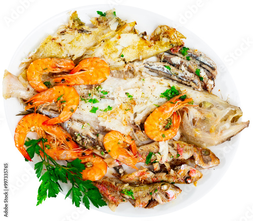 Dish with variety of deep-fried fish pilchard sardine, Lepidorhombus boscii, bluemouth seaperch, sole, mullus surmuletus and shrimp decorated with sprig of parsley complemented with slices of lemon photo
