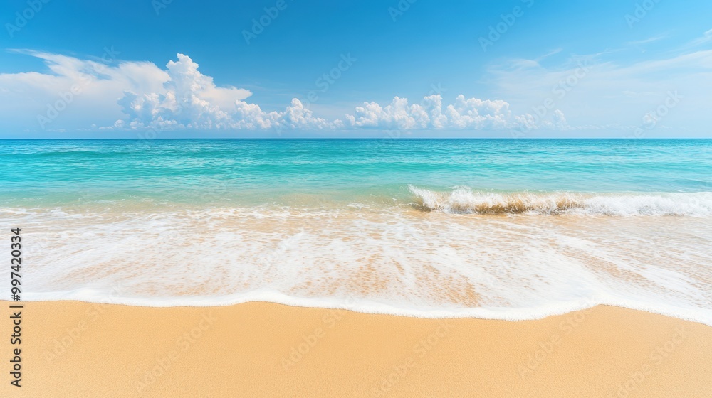 Fototapeta premium The tranquil turquoise waves gently lap against the golden sand, creating a serene atmosphere on a bright, sunny day