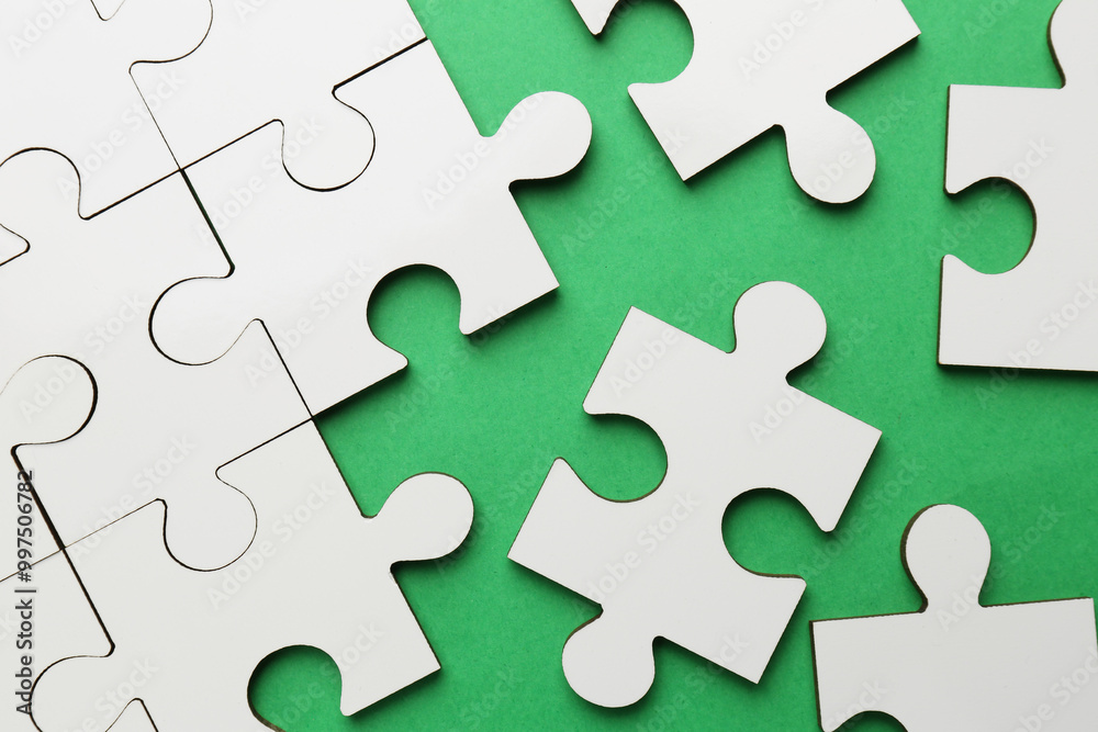 White puzzle pieces on green background, top view White puzzle pieces on green background, top view