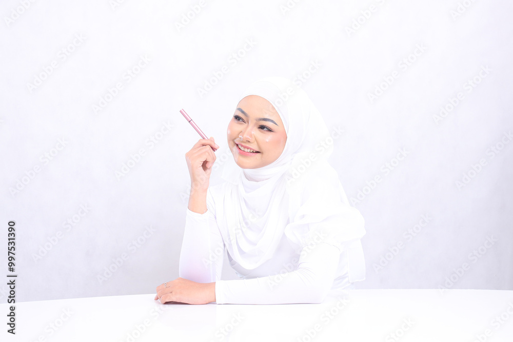 closeup Cheerful adult hijab woman look right above hand holding eyebrow pencil with clean healthy shiny skin isolated on white background. cosmetic advertising concept, eyebrow dye, pencil mock up closeup Cheerful adult hijab woman look right above hand holding eyebrow pencil with clean healthy shiny skin isolated on white background. cosmetic advertising concept, eyebrow dye, pencil mock up