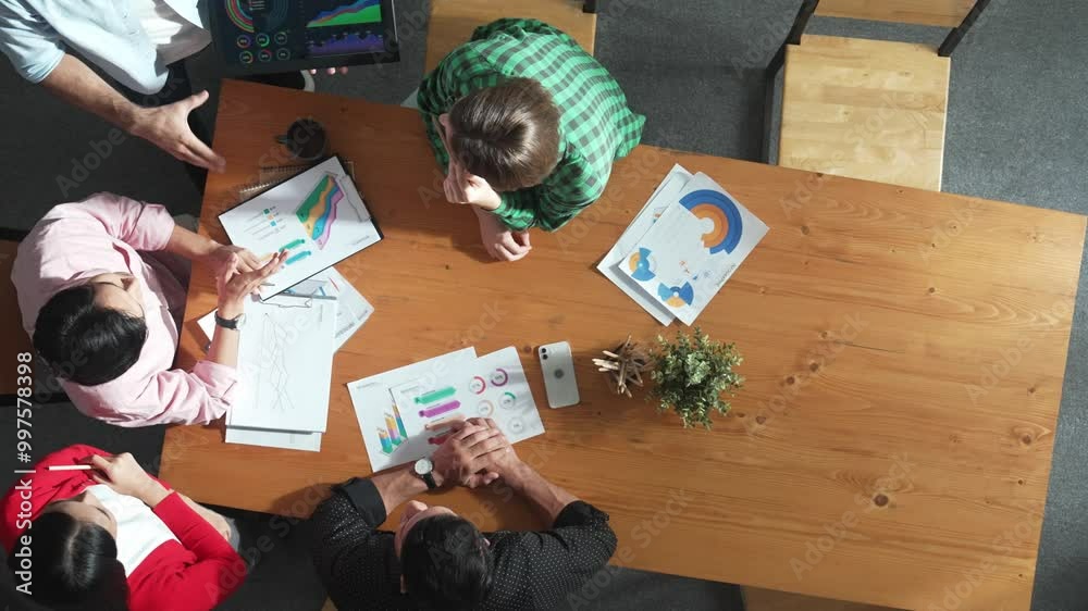 Top down aerial view of smart business man hold tablet and show financial chart at meeting table with financial document. Manager placed tablet at table while investor looking at graph. Convocation.
