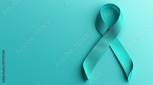 Teal ribbon symbolizing ovarian and cervical cancer awareness on a teal background. photo