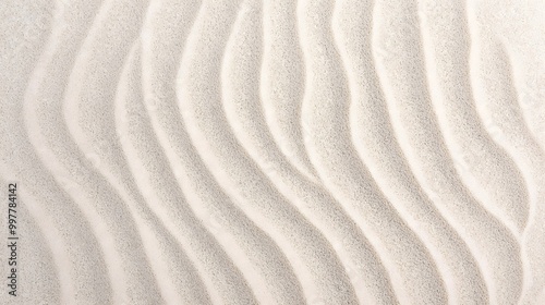 sandy beach with a white line running through it. The line is made up of small, white dots that create a sense of movement and texture. The beach appears to be calm and peaceful