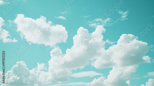 White Clouds on Blue Sky Wallpaper. Soft, fluffy white clouds floating in a pale blue sky.