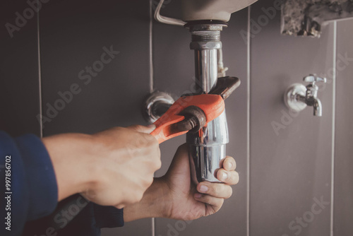 plumber at work in a bathroom, plumbing repair service , fix water plumbing leaks, replace the kitchen sink drain