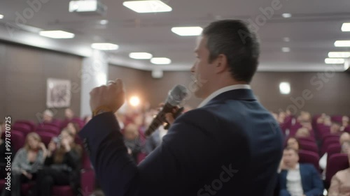 Speaker man with microphone at seminar audience at stage, business people, conference, meeting, congress, coach, speaker, business forum, training, seminar, speech person about management, economics