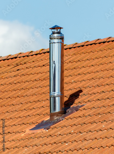 A chimney on a roof with a metal cap