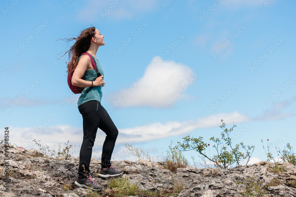 Young woman enjoying nature.Hiking in the mountains, observing the landscape.Doing sports and physical activity.Let's take care of our natural surroundings and our environment.Moments of disconnection Young woman enjoying nature.Hiking in the mountains, observing the landscape.Doing sports and physical activity.Let's take care of our natural surroundings and our environment.Moments of disconnection