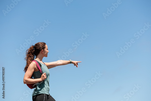 Young woman enjoying nature.Hiking in the mountains, observing the landscape.Doing sports and physical activity.Let's take care of our natural surroundings and our environment.Moments of disconnection